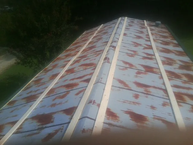 Rusted metal roof panels with new wood purlins before replacement — Storm Damage Roof Repair in Indian Springs by Roofing Brothers